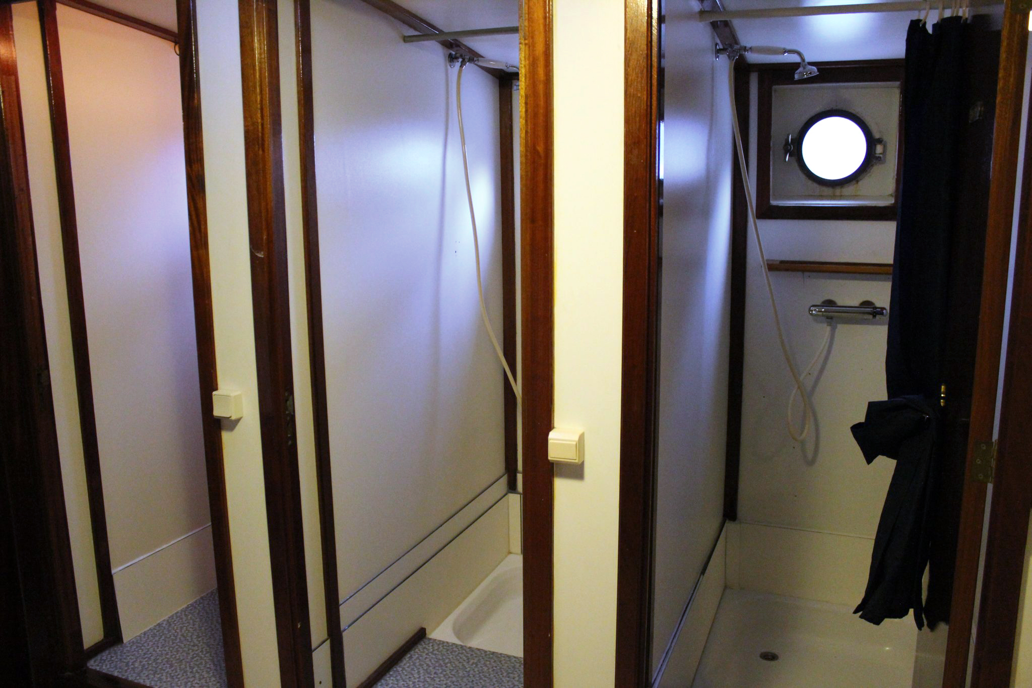 Natte cellen, de douches aan boord van een schip, geschikt voor grotere gezelschappen getypeert door bruin gelakt hout.