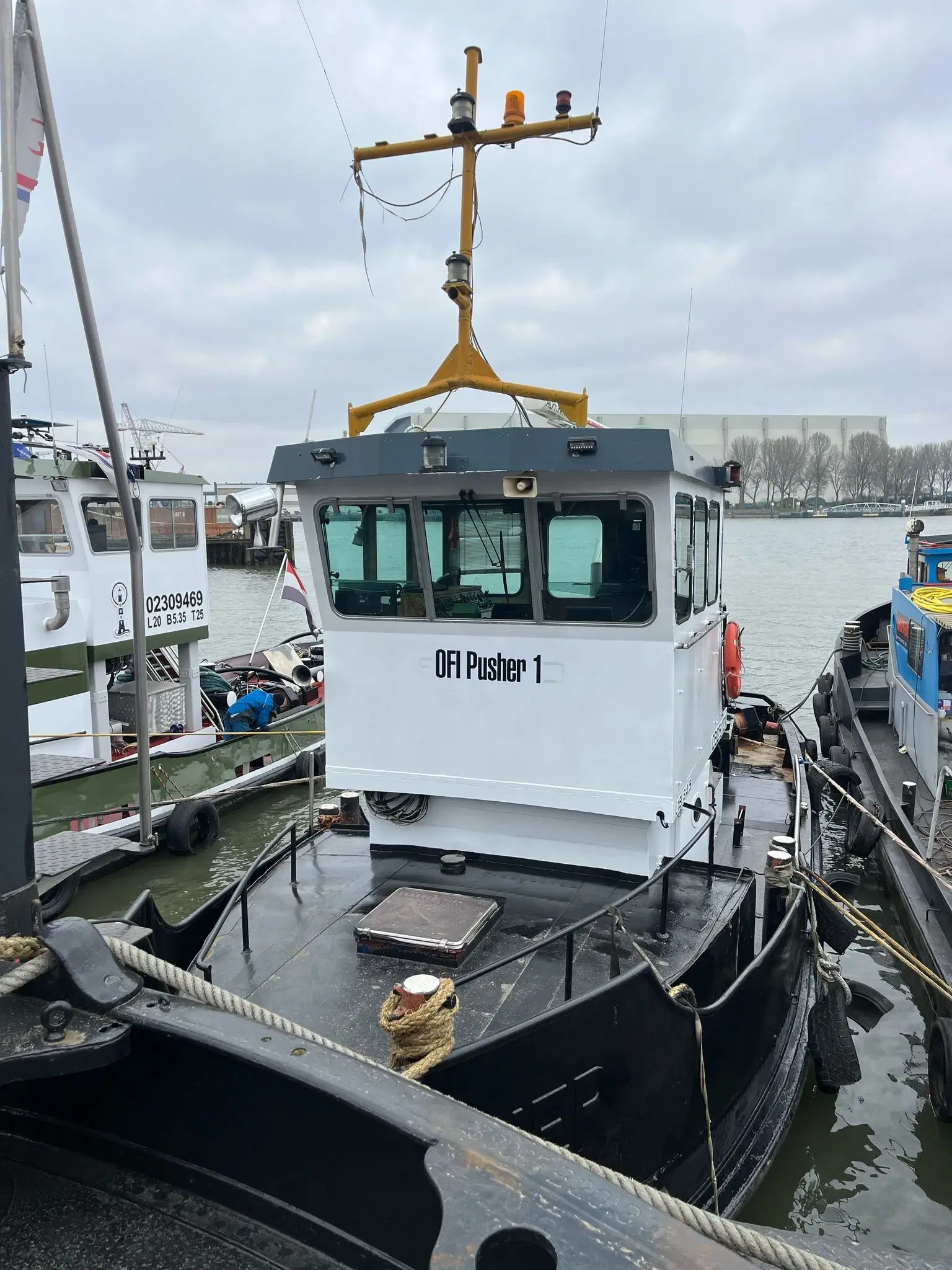 Een boot ligt met landvasten aan de kader met duidelijk zichtbaar OFI Pusher 1